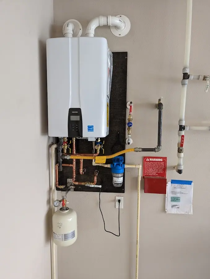 Professional plumber installing copper piping in a Anna home